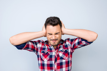 Noo! Stop! Close up of a stressed young brunet man with closed eyes and struggle grimace. He is in...