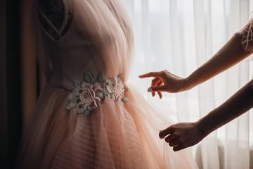 Woman reaches her hands out to the beautiful ivory bed