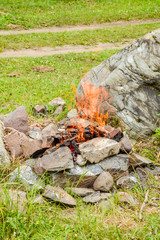 Camp fire. Bonfire diluted in the rocks against the background of the forest