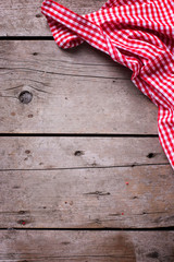 Red and white kitchen towel on rustic wooden background.