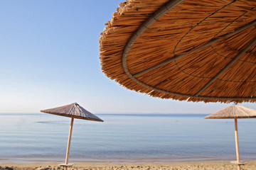 Straw Beach Umbrellas against blue sea. Summer, holiday, vacation background