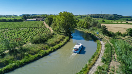 Aerial top view of boat in Canal du Midi from above, family travel by barge and vacation in Southern France
 - obrazy, fototapety, plakaty