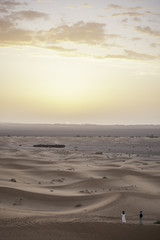 Sunrise in desert with people in front, Erg Chebbi, Morocco