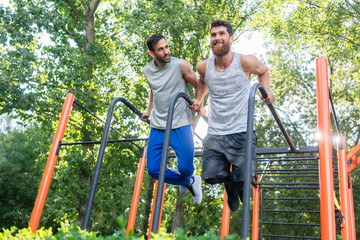 zwei junge Männer beim Street workout sport im Sommer für bessere Fitness bei Dips