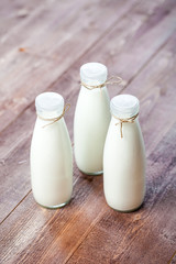 bottles of milk on a wooden rustic table.