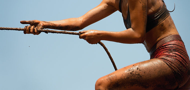 Mud race runners,defeating obstacles by using ropes