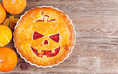 Delicious homemade pie for halloween with a filling of pumpkin-strawberry jam and peaches