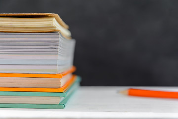 book and pencil on white table black board background with study and education