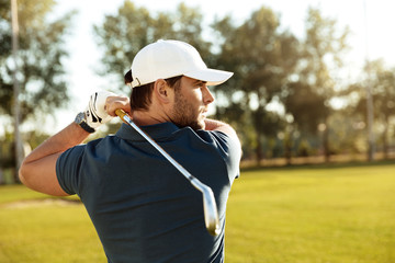 Close up of a young concentrated man shooting golf ball - Powered by Adobe