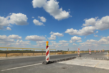 Roadworks, road signs at a highway or road in reconstruction with blue sky and clouds