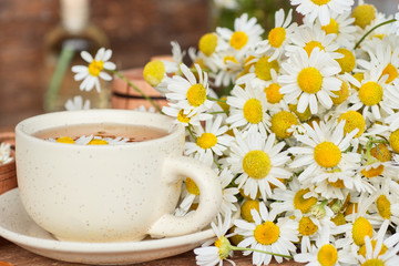 Fototapeta na wymiar cup of herbal chamomile tea with camomile dry blossoms, dried camomile flowers. doctor treatment and prevention of immune concept, medicine - folk, alternative, complementary, traditional medicine 
