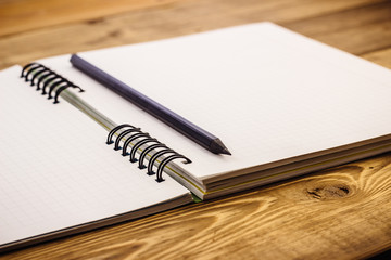 pencil on notebook with bookmarks lying on a wooden table