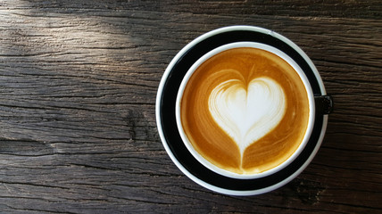 Cup of Latte art with heart shape on old wooden background,top view , mobile phone photography
