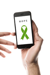 Hand holding smartphone, blank screen with lime ribbon isolated on white background. World Cancer Day. Lymphoma cancer, liver cancer concept