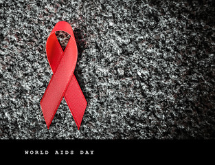red ribbon on granite, world aids day concept