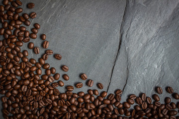 Coffee beans on nature black stone slate background