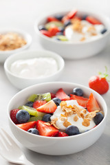 fruit berry salad with yogurt and granola for healthy breakfast