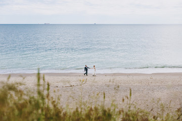 Groom and bride on a walk outdoors at the sea