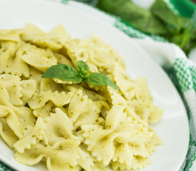  Farfalle pasta with pesto genovese (basil sauce) on white rustic wooden table. Italian cuisine