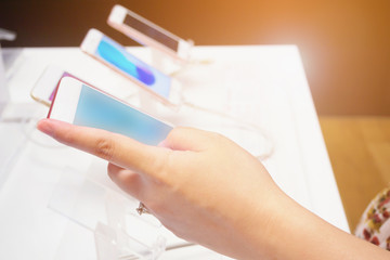 woman choosing new mobile smartphone in store