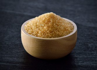 sugar in wood bowl on black wood