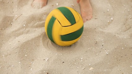 Detail of hands spinning the ball on the sand