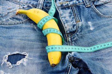 Banana wrapped with blue measure tape on jeans, selective focus