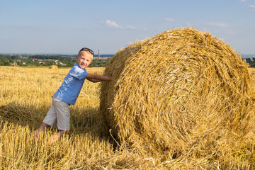 Naklejka na ściany i meble Boy near a hay bale