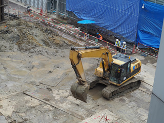Fototapeta premium workers in construction area with crane truck and holding machine