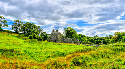 Obraz premium Inch Abbey with a blue sky in Northern Ireland. Monastery ruins in Downpatrick. Co. Down. Travel by car in summer.