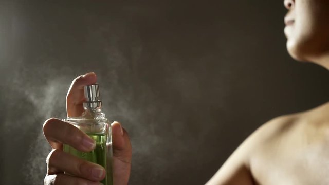 Slow motion, Sensual woman spraying fragrance with scent particles to skin. 
