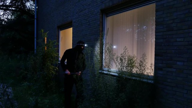 Burglar using crowbar to break into a house at night &ndash; 4K