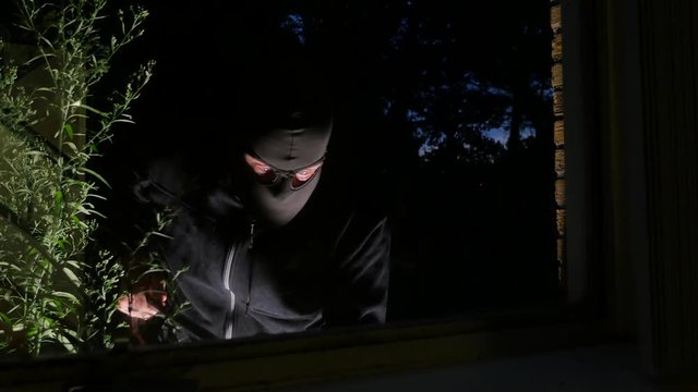 Burglar using crowbar to break into a house at night – 4K