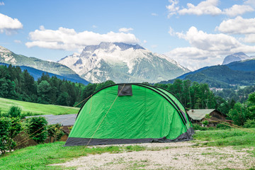 a big green tent with mountian background on camping holidays