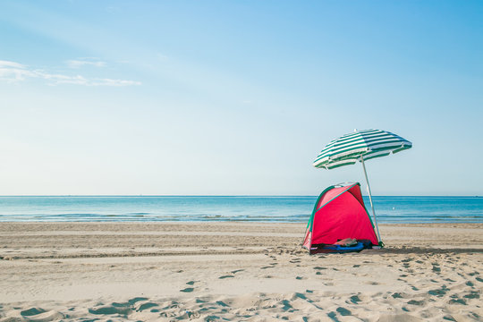 colorful of red tent and blue beach umbrella on the beach 