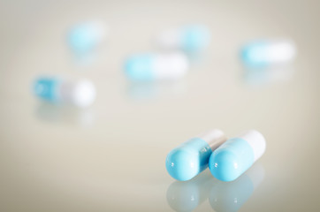 Pharmacy theme. Blue and White Isolated Capsules on the White Surface. Closeup.