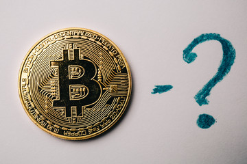 Bitcoin coin and question mark at white background