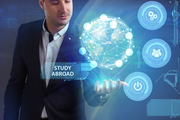 Business, Technology, Internet and network concept. Young businessman working on a virtual screen of the future and sees the inscription: Study abroad
