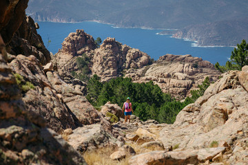 Woman hiking on a trail in the mountains of Corsica, France. Old film style.