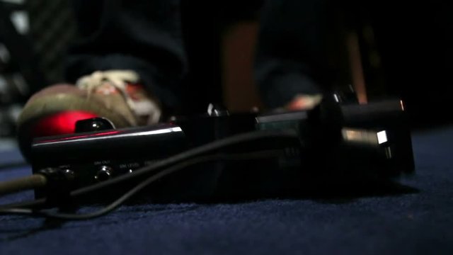 Cinemagraph of guitarist presses with his foot on the effects pedal