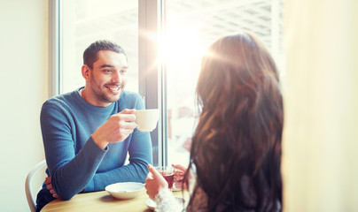 happy couple drinking tea and coffee at cafe