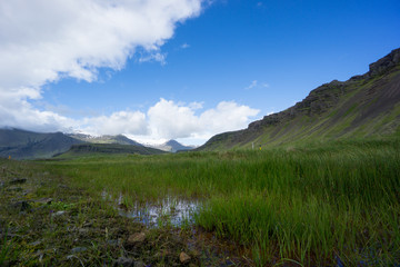 Iceland - Green mountainous landscape with snow covered peaks