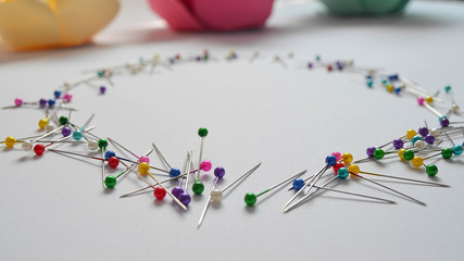 Pins places in circle shape on the white background, close up