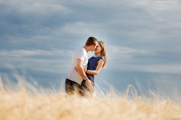 Happy young couple enjoying in the wheat field, summer season