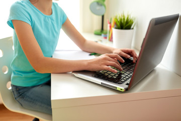 Naklejka premium girl typing on laptop at home