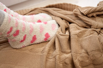 Fototapeta na wymiar woman or girl feet in socks and knitted plaid