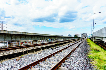 Obraz premium side view of railway track and crushes rock near the bridge with blue sky and cloudy background. milestone concept