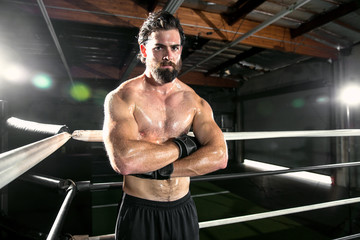 Fototapeta na wymiar Intense extreme sports fighter boxer mma athlete posing in tough intimidating pose with arms folded