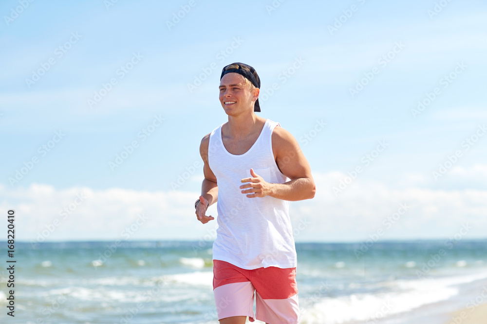 Wall mural happy man running along summer beach