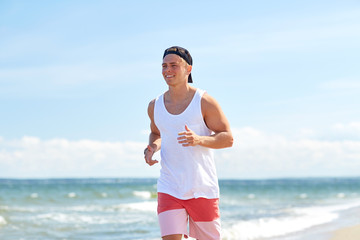 happy man running along summer beach